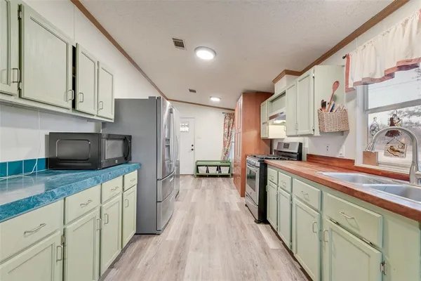 a kitchen with stainless steel appliances granite countertop a sink and wooden cabinets