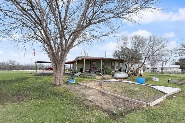 a backyard of a house with table and chairs