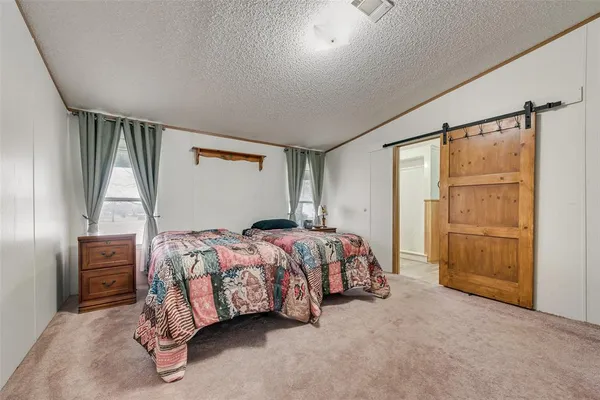 a bed sitting in a bedroom next to a window