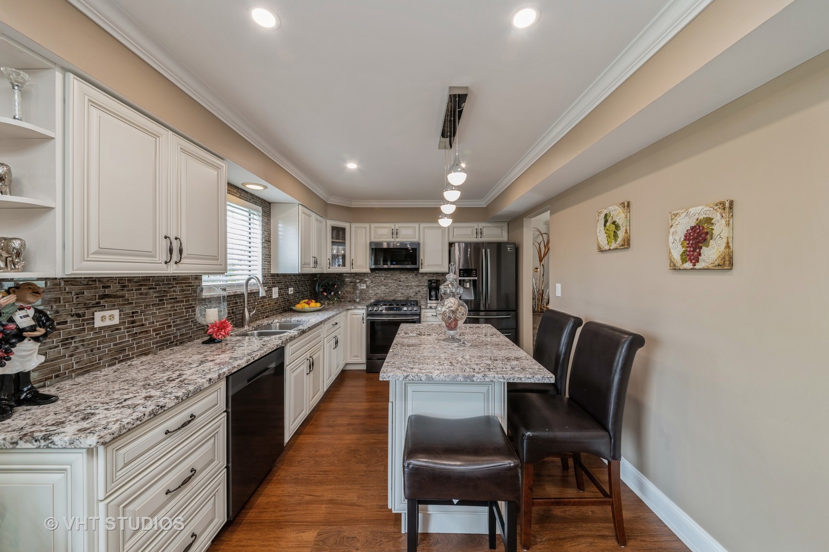 1026 Longford Road Bartlett, IL 60103 - Photo 6 of 24 a large white kitchen with stainless steel appliances granite countertop a sink dishwasher a stove a dining table and chairs with wooden floor