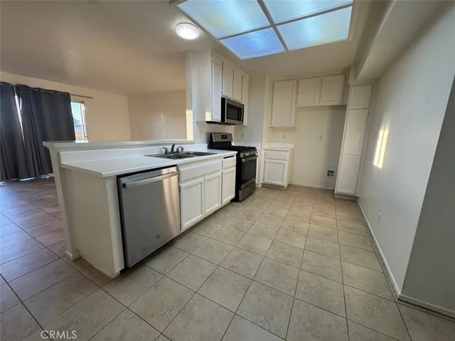 a stove top oven sitting inside of a kitchen and white cabinets