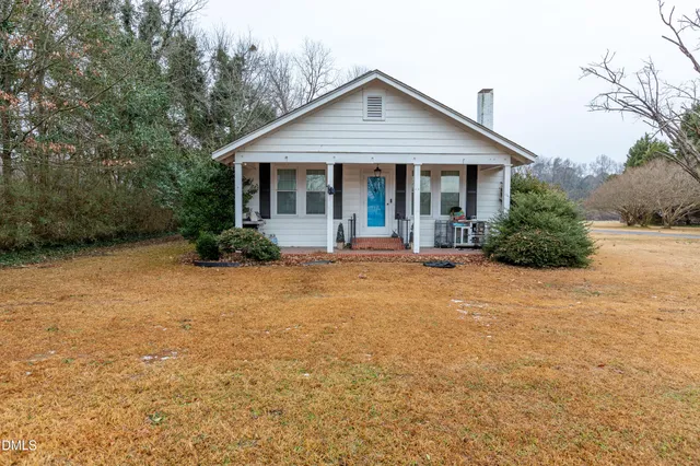 a front view of a house with yard and green space