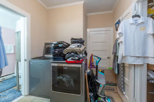 a utility room with dryer washer and a view of living room