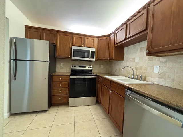 a kitchen with stainless steel appliances a refrigerator stove and sink