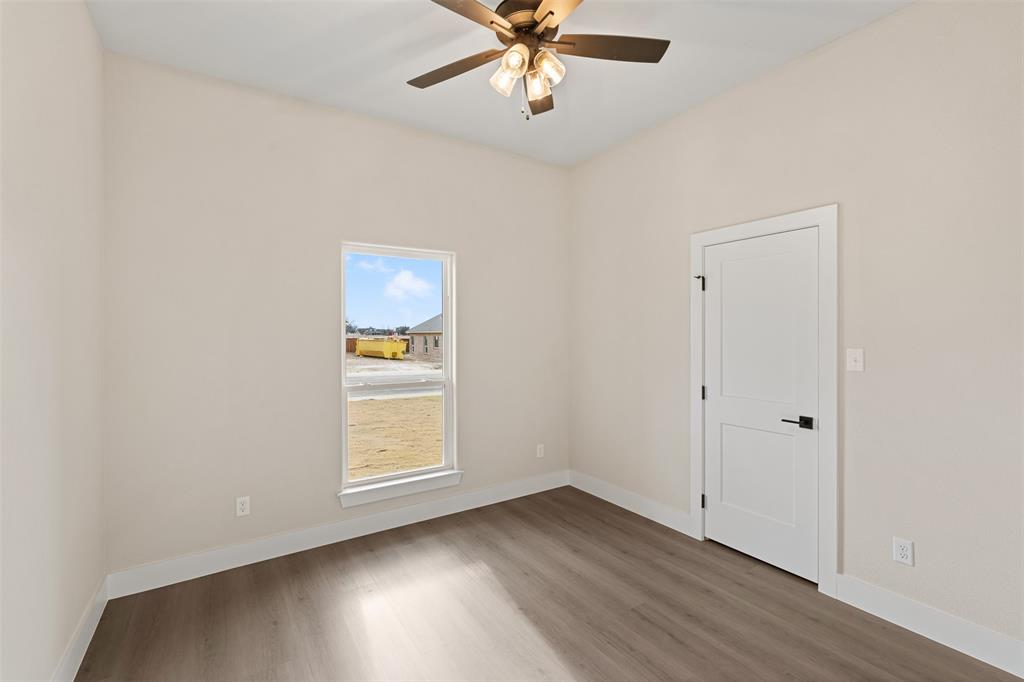 506 Limestone Circle Mabank, TX 75147 - Photo 18 of 33 an empty room with wooden floor chandelier fan and windows
