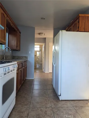 a kitchen with a stove top oven and refrigerator