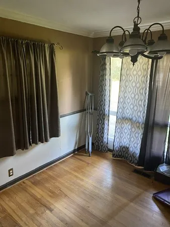 a view of a room with wooden floor and windows