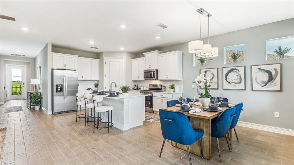 17911 Shade Tree Loop Babcock Ranch, FL 33982 - Photo 8 of 44 a view of a dining room and livingroom with furniture wooden floor a chandelier