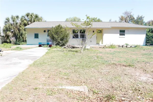 a front view of house with yard and trees around