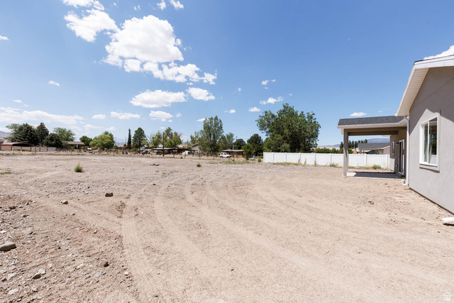 51 West 500 South Monroe, UT 84754 - Photo 25 of 41 Expansive, undeveloped lot with a partially visible exterior wall, covered patio, and a white perimeter fence