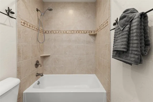 a bathroom with a bath tub with a shower