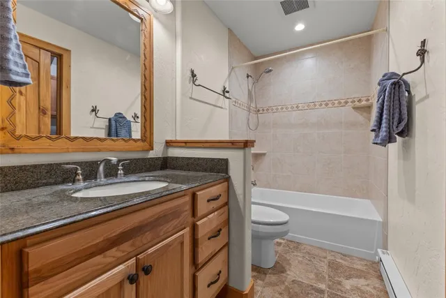 a bathroom with a granite countertop sink toilet and shower