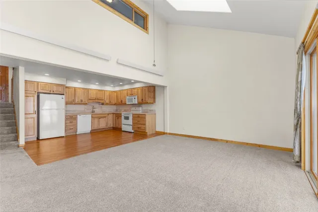 an empty room with a kitchen and a window