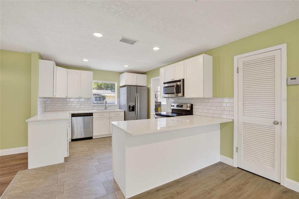 2340 Merrily Circle South Seffner, FL 33584 - Photo 12 of 52 a kitchen with refrigerator cabinets and wooden floor