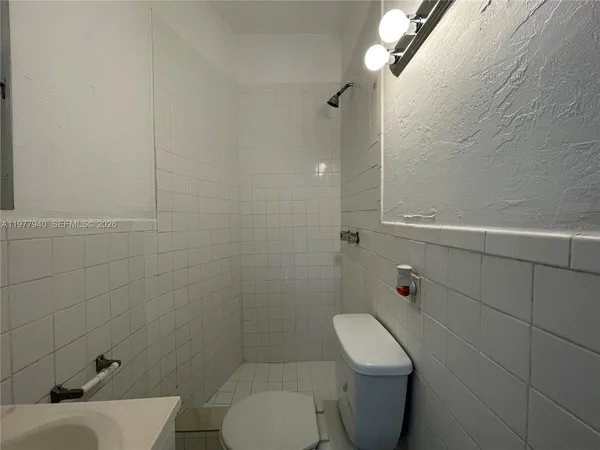 a bathroom with a toilet a sink and shower