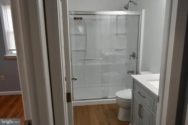 a view of empty room with wooden floor