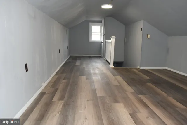 a bathroom with a toilet and a wooden floor