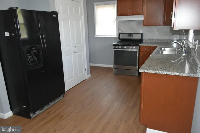 a kitchen with granite countertop a refrigerator and a stove