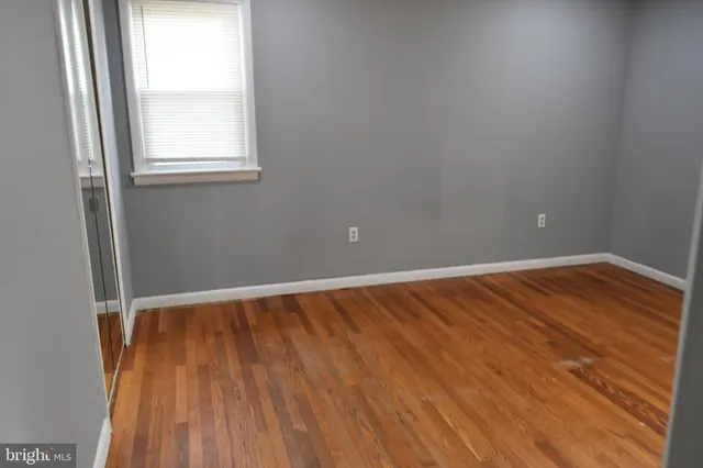 an empty room with wooden floor and closet