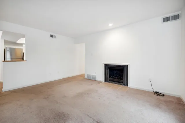 a view of empty room with floor to ceiling window and fireplace
