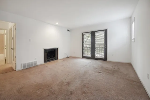 a living room with furniture a fireplace and a large window