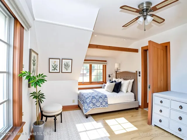 a bedroom with a large bed and wooden floor