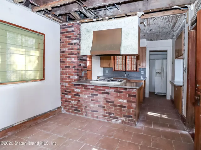 a view of open kitchen with a sink and a refrigerator