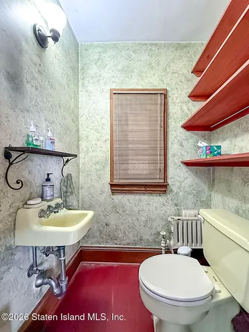 a bathroom with a toilet a sink and a mirror