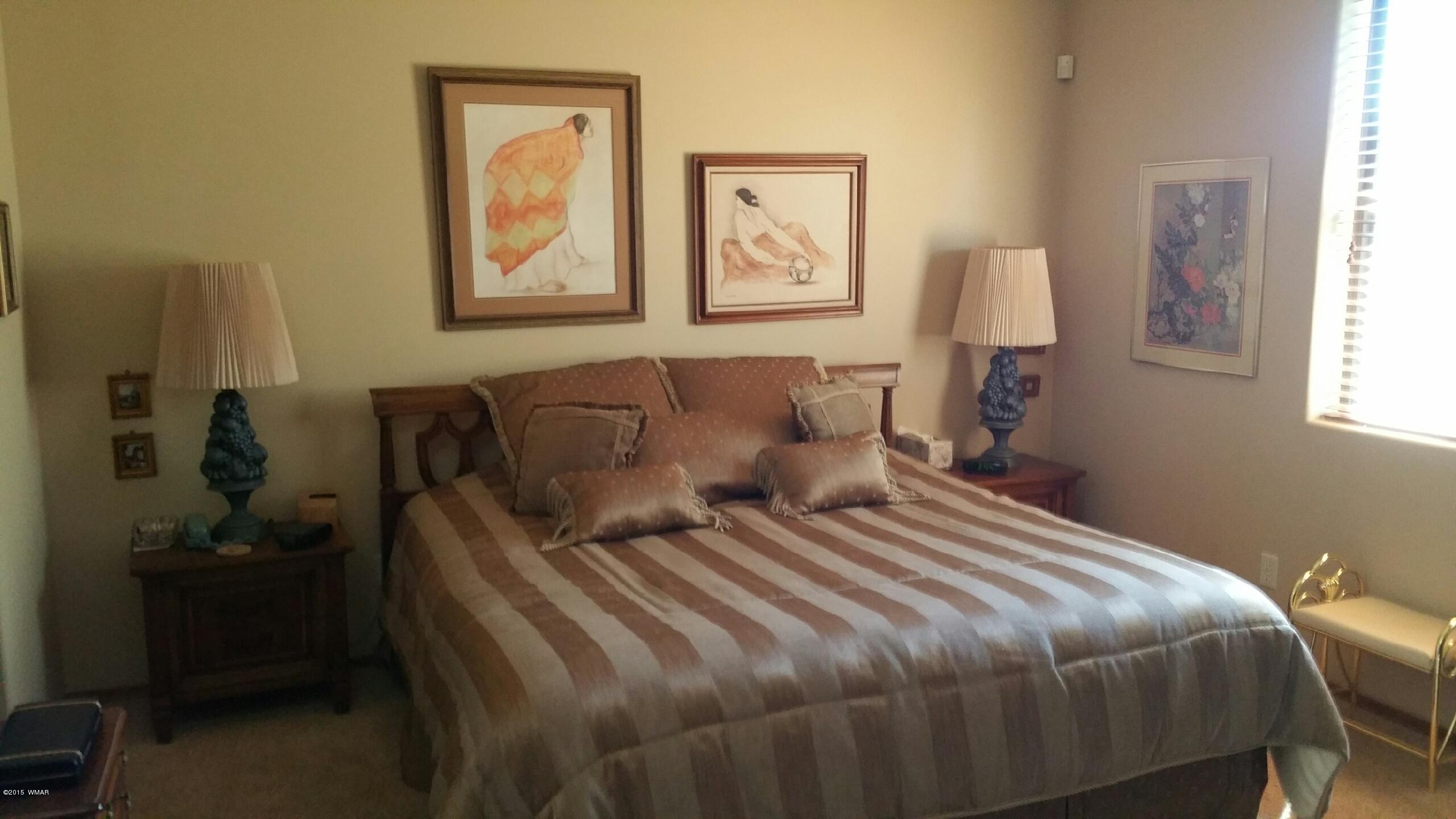 2831 West Villa Loop, Unit 102 Show Low, AZ 85901 - Photo 2 of 6 a bedroom with a bed and a lamp on dresser