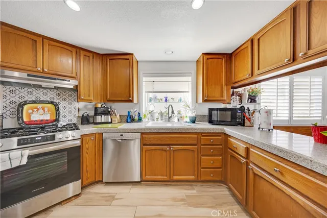 a kitchen with stainless steel appliances granite countertop a stove sink and cabinets