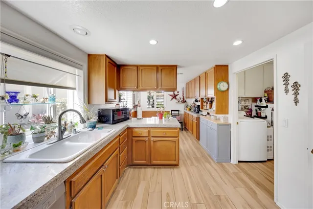 a kitchen with kitchen island granite countertop a sink cabinets and stainless steel appliances