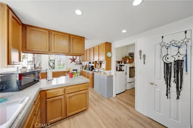 a kitchen that has a lot of cabinets a sink and wooden floor