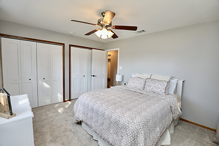 100 Lee Street Manhattan, IL 60442 - Photo 12 of 21 a bedroom with a bed and a chandelier