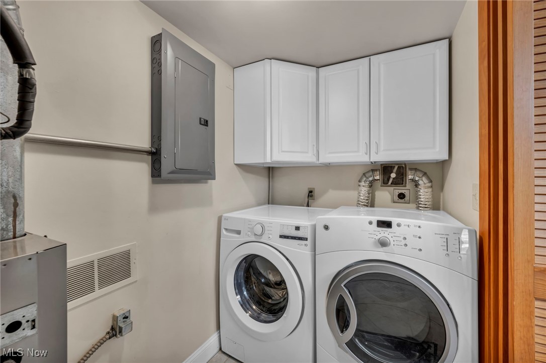 1263 Lost Nation Road, Unit 5 Willoughby, OH 44094 - Photo 24 of 26 Laundry room with electric panel, washing machine and clothes dryer, cabinet space, and heating unit
