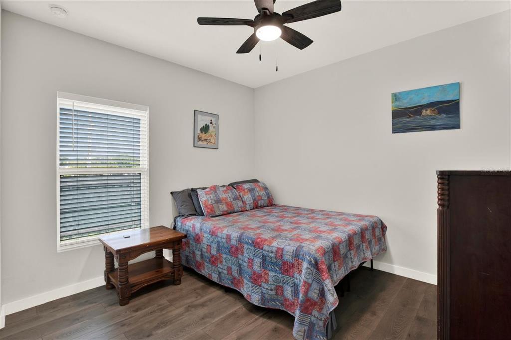 3023 Muir Street Holiday, FL 34691 - Photo 15 of 25 a bedroom with a bed and a chandelier