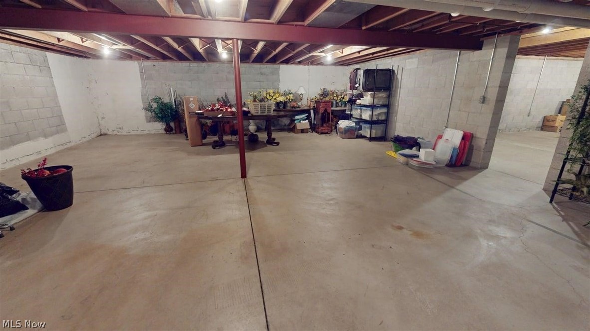 3985 Wiers Road Willard, OH 44890 - Photo 50 of 50 Unfinished lower level featuring concrete flooring, exposed ceiling joists, overhead lighting, concrete block walls, and structural beams