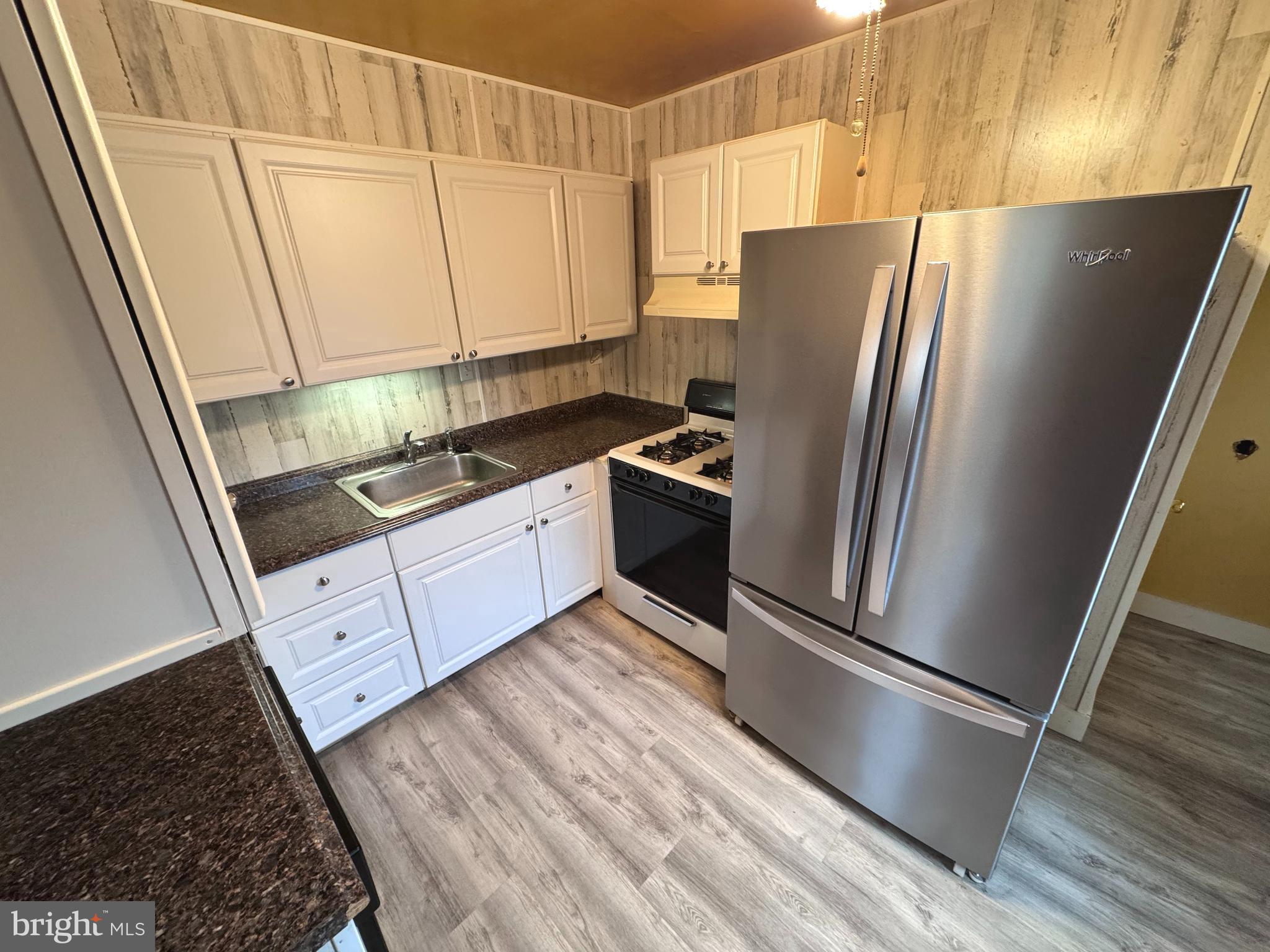 1705 Summit Avenue Baltimore, MD 21227 - Photo 2 of 7 a kitchen with stainless steel appliances a refrigerator sink and cabinets