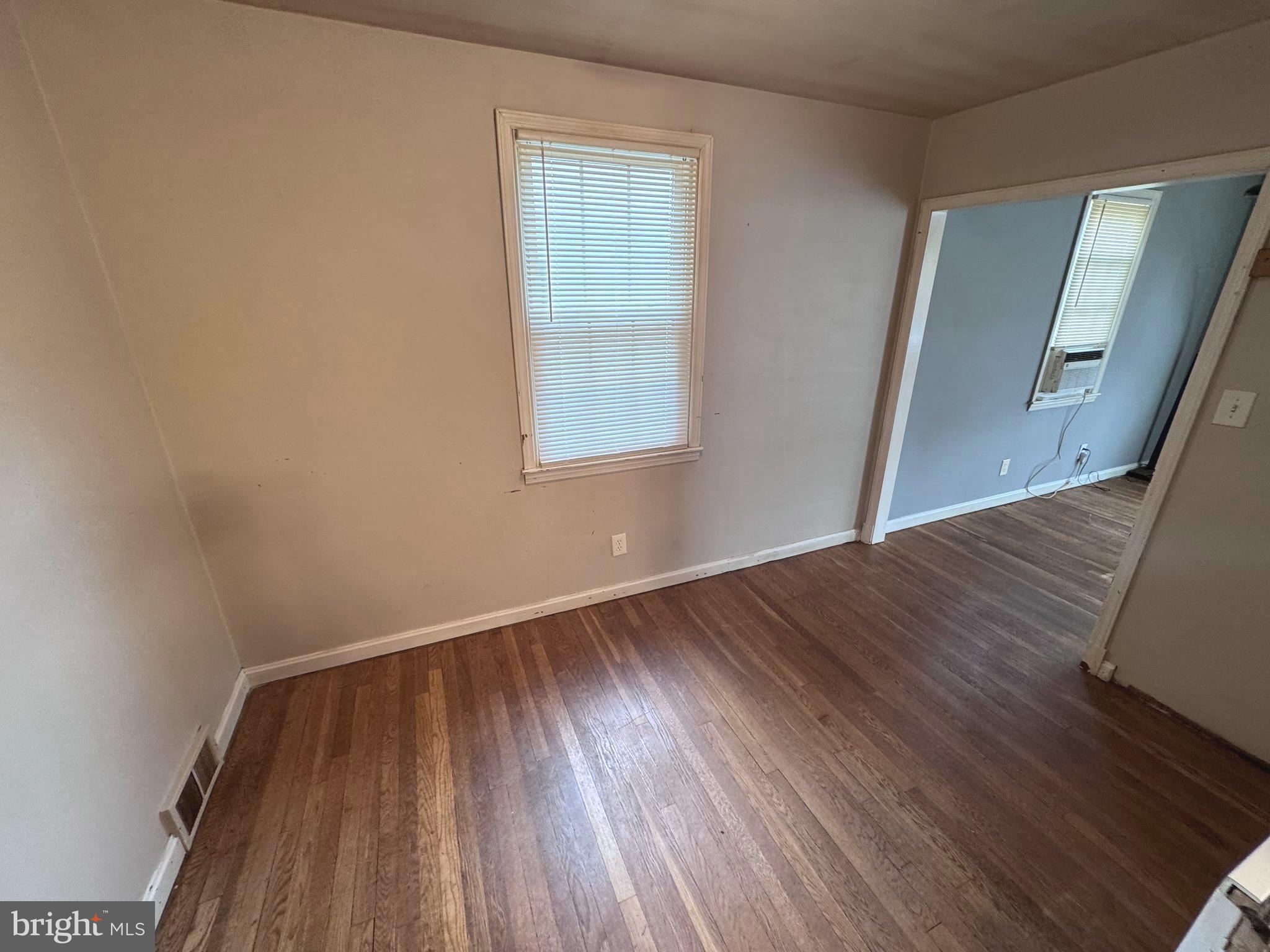 1705 Summit Avenue Baltimore, MD 21227 - Photo 7 of 7 an empty room with wooden floor and windows