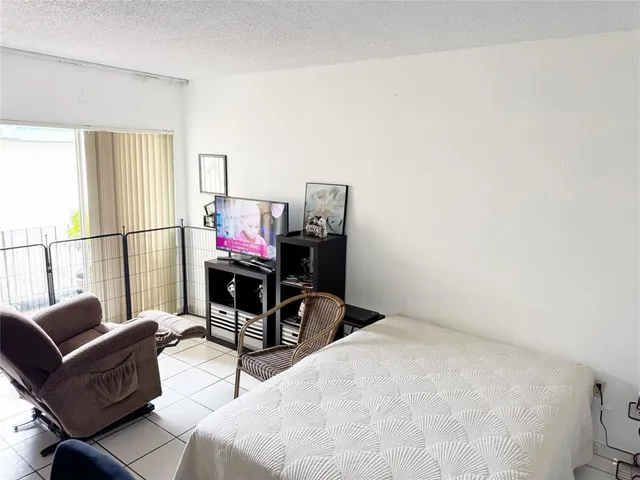 a living room with furniture a flat screen tv and a window