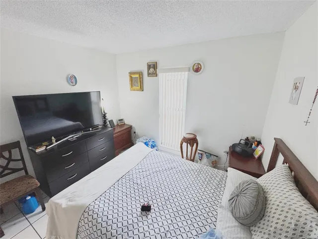 a bedroom with a bed and flat screen tv