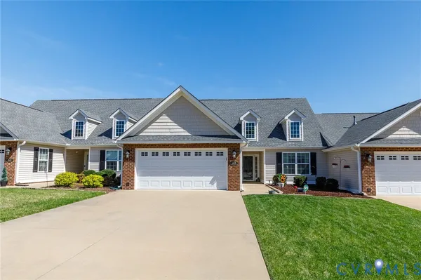 a front view of a house with a garden and plants