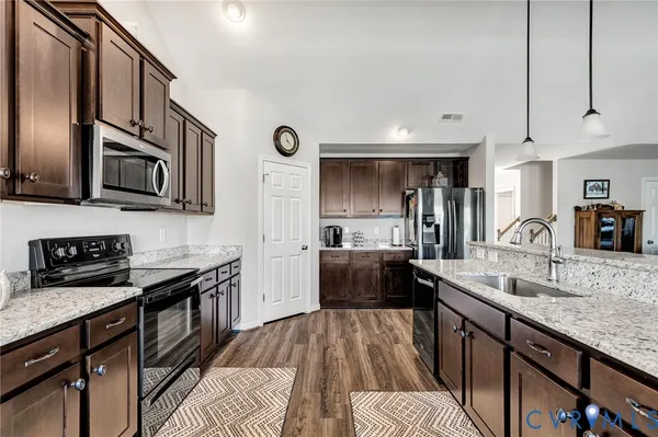 a kitchen with stainless steel appliances granite countertop a sink stove microwave and cabinets