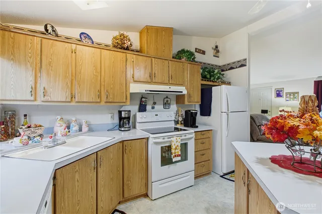 a kitchen with stainless steel appliances granite countertop a refrigerator sink and white cabinets