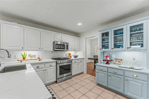 a kitchen with stainless steel appliances granite countertop a sink dishwasher stove top oven and cabinets
