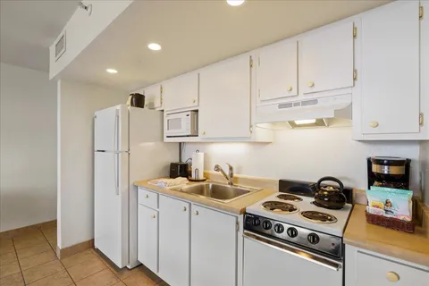 a kitchen with stainless steel appliances granite countertop white cabinets a stove a refrigerator and a sink