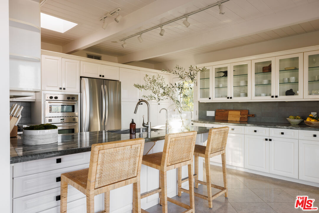 3272 Wrightwood Drive Studio City, CA 91604 - Photo 9 of 36 a kitchen with stainless steel appliances kitchen island granite countertop a refrigerator a stove a sink and white cabinets with wooden floor