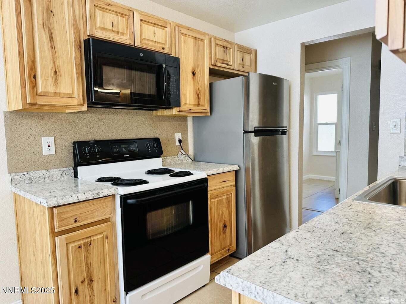 3927 Clear Acre Lane, Unit 207 Reno, NV 89512 - Photo 2 of 33 a kitchen with stainless steel appliances granite countertop a stove microwave refrigerator and sink