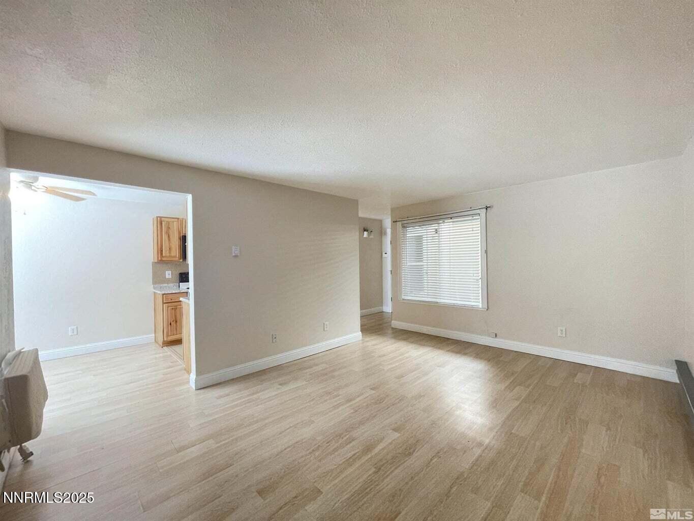 3927 Clear Acre Lane, Unit 207 Reno, NV 89512 - Photo 8 of 33 an empty room with wooden floor and windows