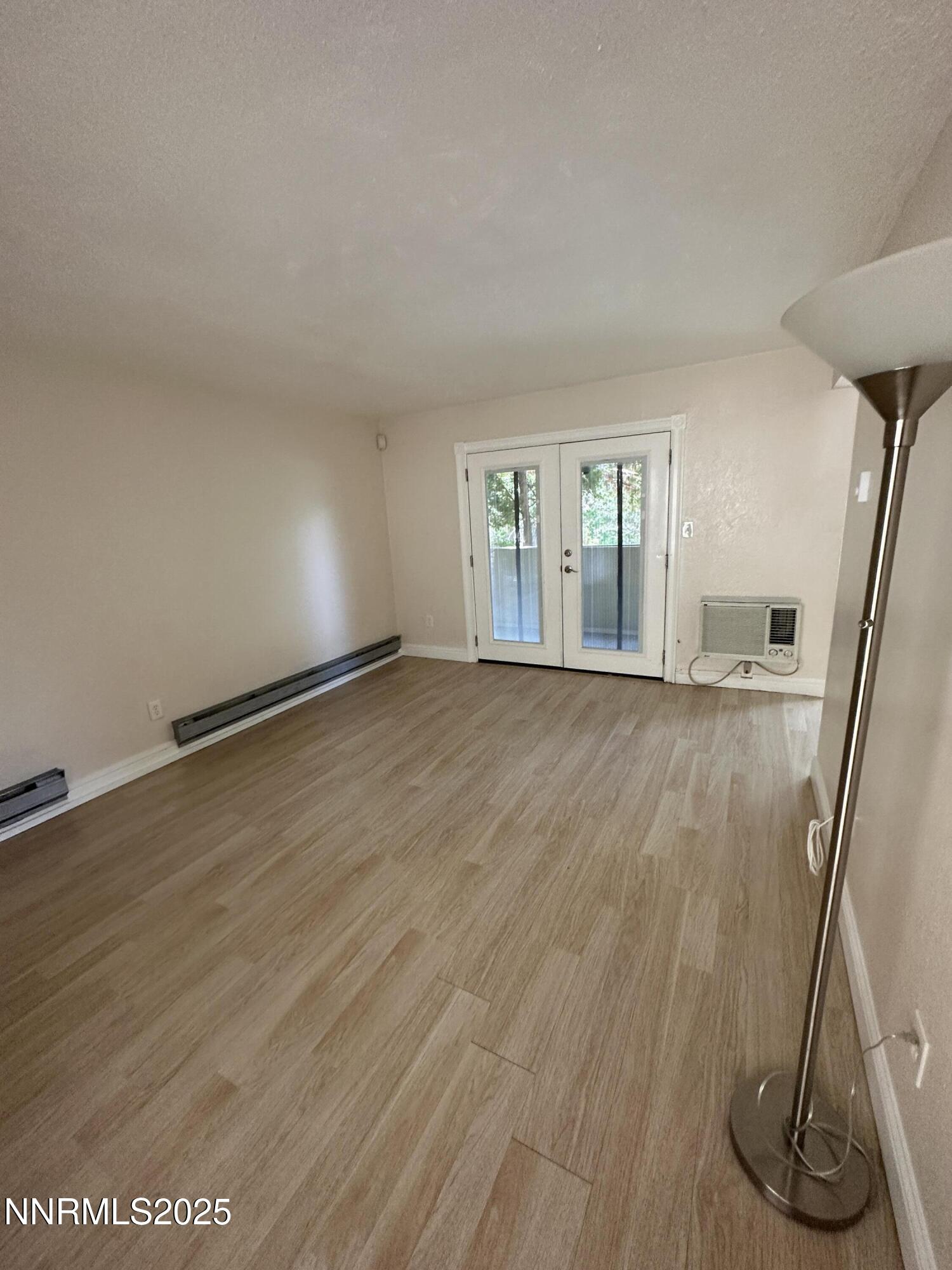 3927 Clear Acre Lane, Unit 207 Reno, NV 89512 - Photo 10 of 33 an empty room with wooden floor and glass door