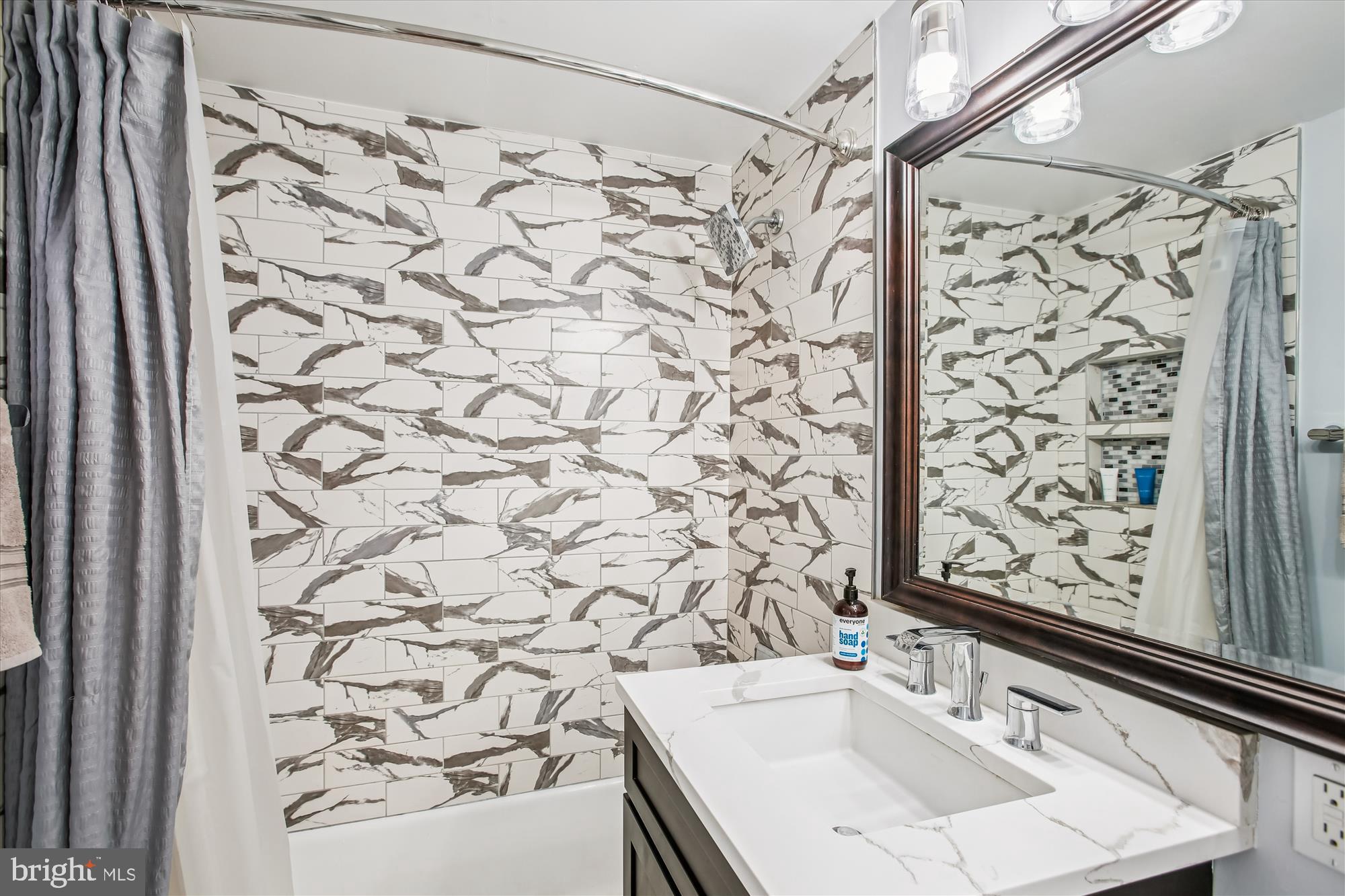 1311 Delaware Avenue Southwest, Unit S331 Washington, DC 20024 - Photo 17 of 35 a bathroom with a sink and a shower curtain